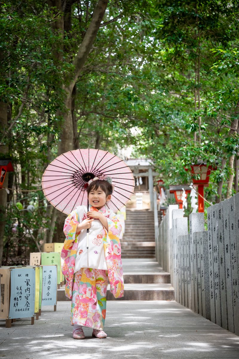 参道で番傘を差す七五三の女の子