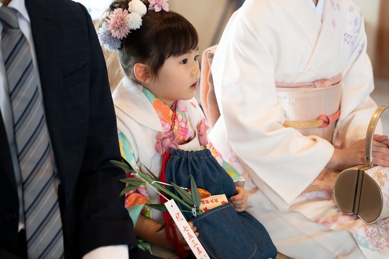 千歳飴を抱えてご祈祷を待つお子様
