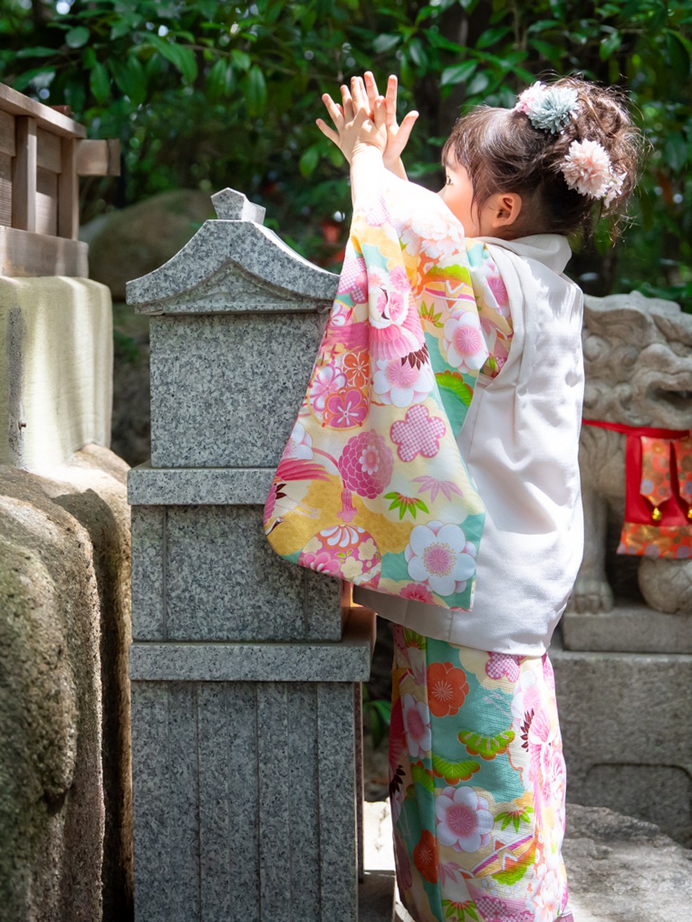 末社に手を合わせる七五三の女の子